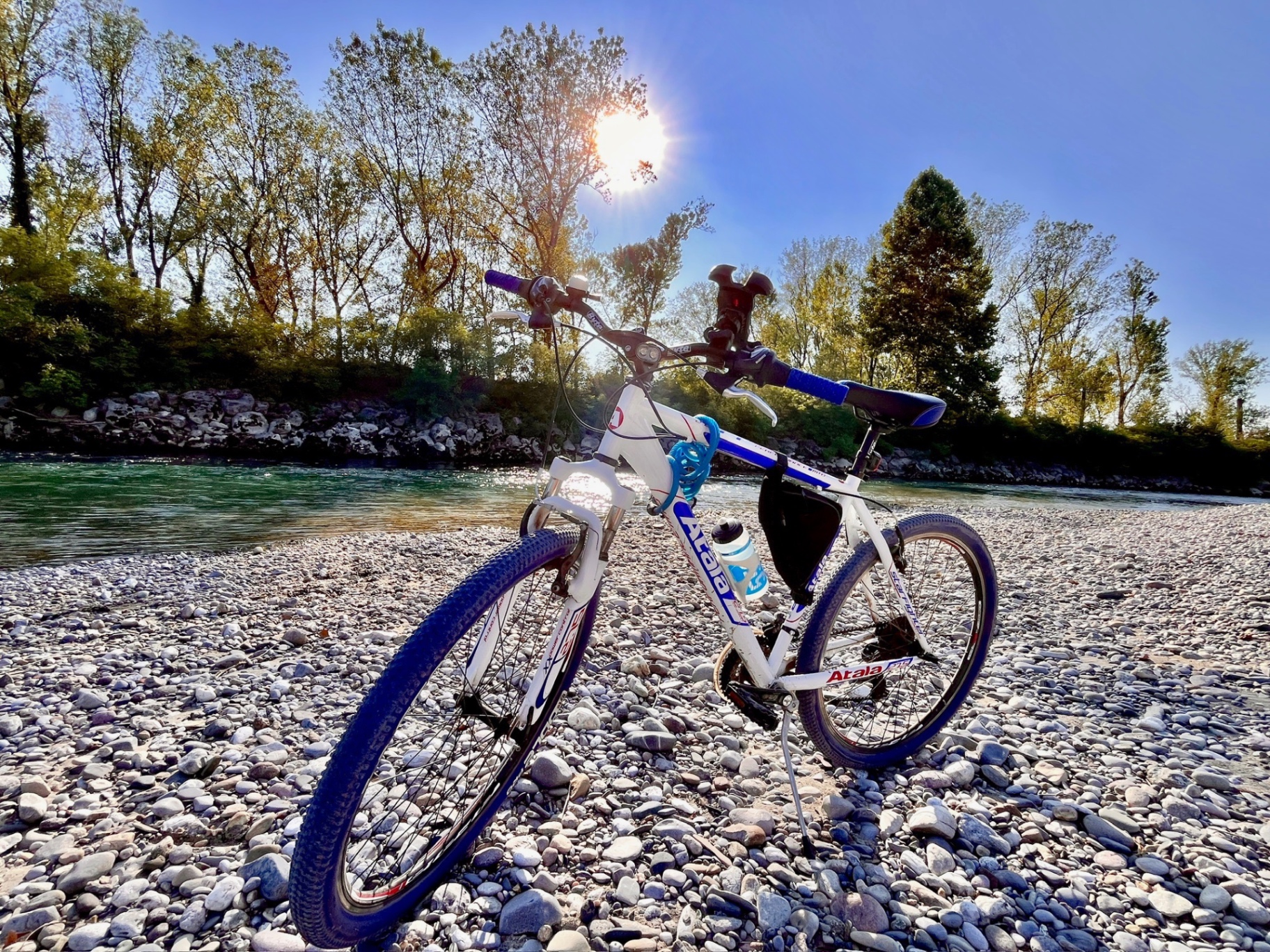 Bicicletta sulla spiaggia di sassi dell'Oglio al tramonto