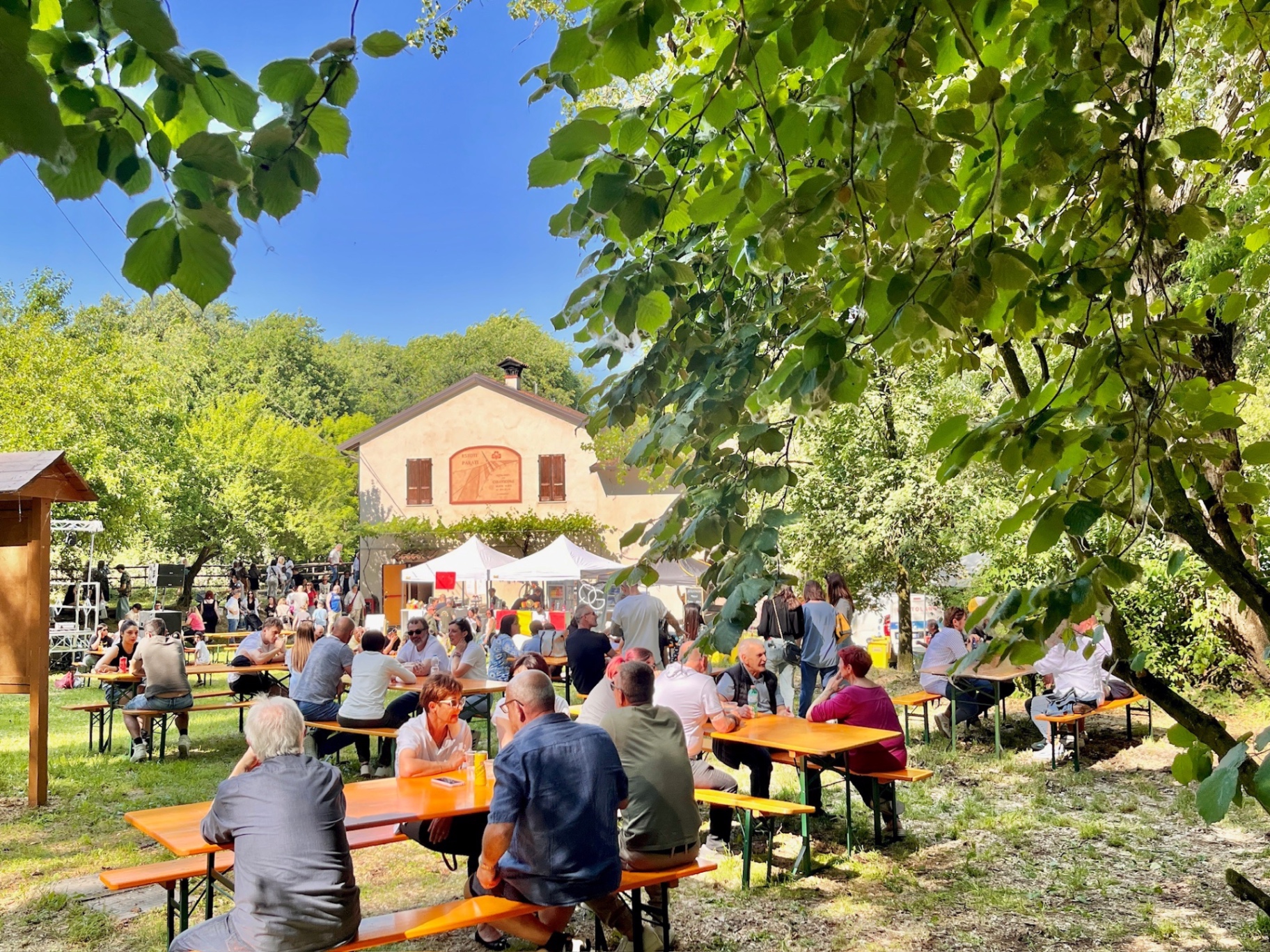Festa all'aperto con tavolate tra gli alberi